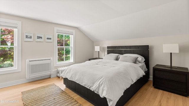 bedroom featuring light hardwood / wood-style flooring and vaulted ceiling