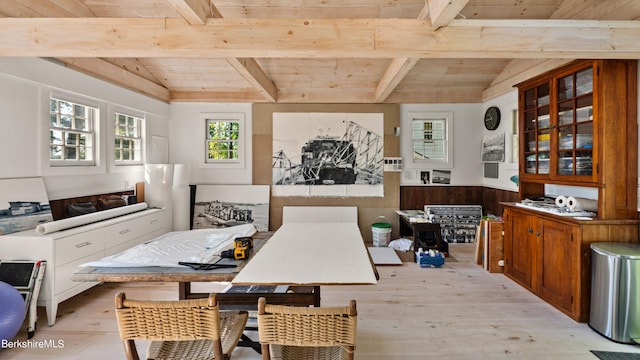 dining space with vaulted ceiling with beams, wood walls, wooden ceiling, and light hardwood / wood-style flooring