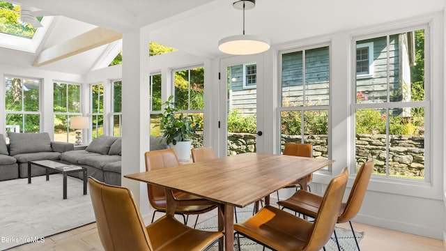 sunroom featuring vaulted ceiling with skylight