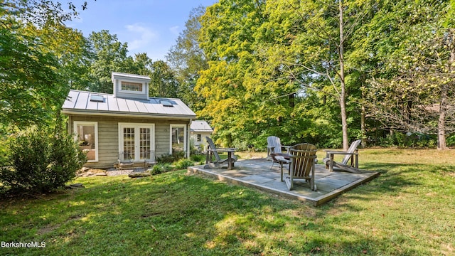 rear view of property with a lawn, a patio area, and french doors