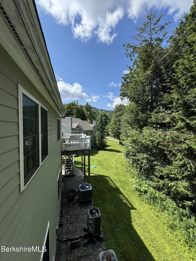 view of yard with a deck and central air condition unit