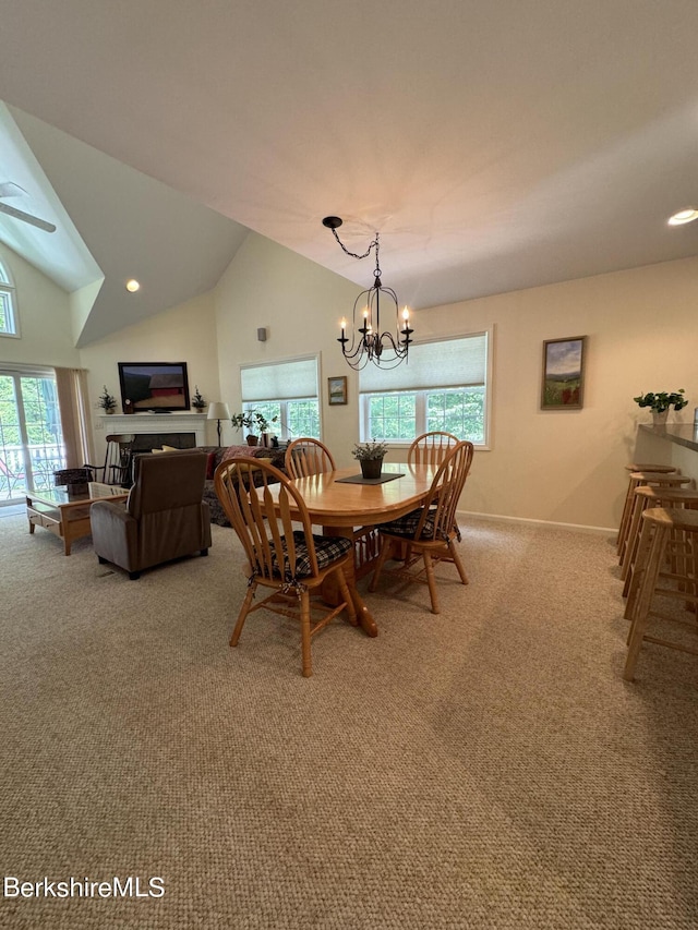 dining area with light colored carpet, lofted ceiling, and an inviting chandelier