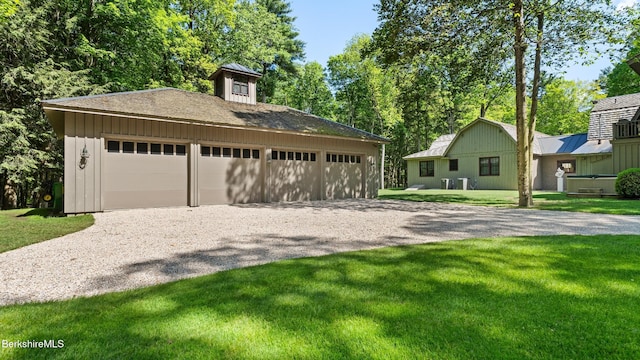 232 Giberson Rd, Sheffield, MA 01257 - view of front of house featuring an outbuilding, a garage, driveway, a front lawn, and board and batten siding