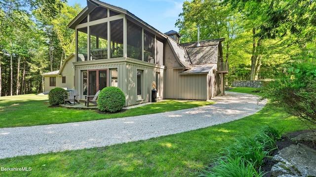 232 Giberson Rd, Sheffield, MA 01257 - rear view of property with a sunroom, board and batten siding, a lawn, and gravel driveway