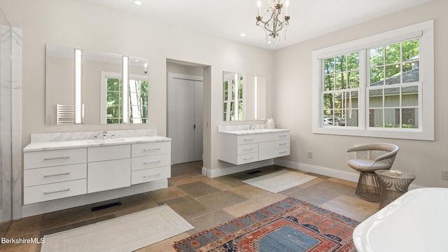 232 Giberson Rd, Sheffield, MA 01257 - full bathroom featuring two vanities, a freestanding tub, baseboards, a chandelier, and stone finish flooring