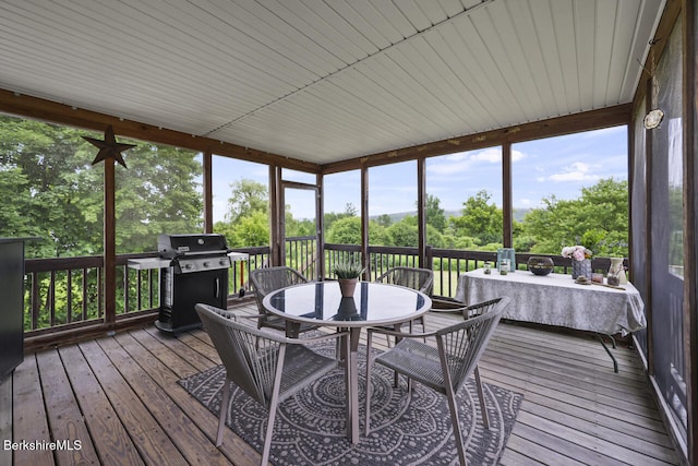 927 Holmes Rd, Pittsfield, MA 01201 - sunroom featuring outdoor dining area, a wooden deck, hardwood / wood-style flooring, and view of scattered trees