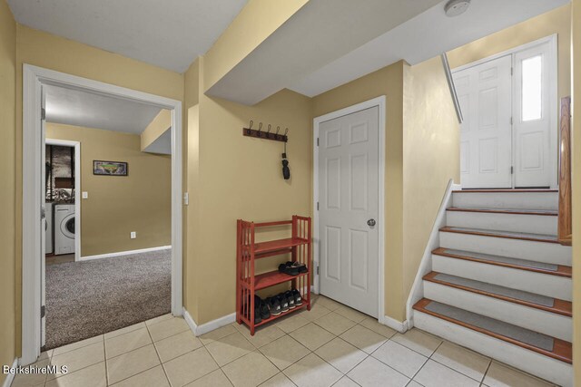 927 Holmes Rd, Pittsfield, MA 01201 - entryway with washer / dryer, stairway, light tile patterned floors, and light colored carpet