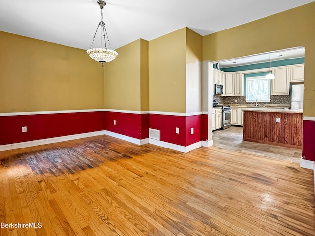 432 Grange Hall Rd, Dalton, MA 01226 - unfurnished living room featuring light wood-style floors, baseboards, and a sink