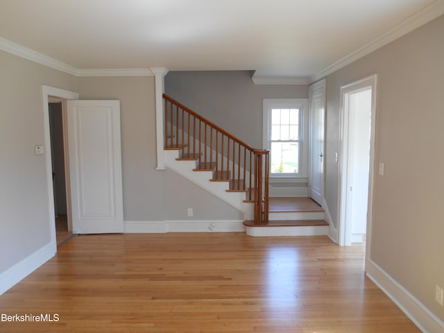 stairs featuring crown molding, baseboards, and wood finished floors