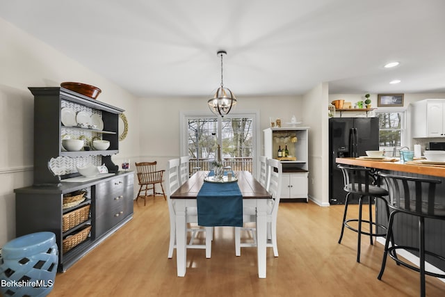 dining space with light wood-type flooring and a chandelier