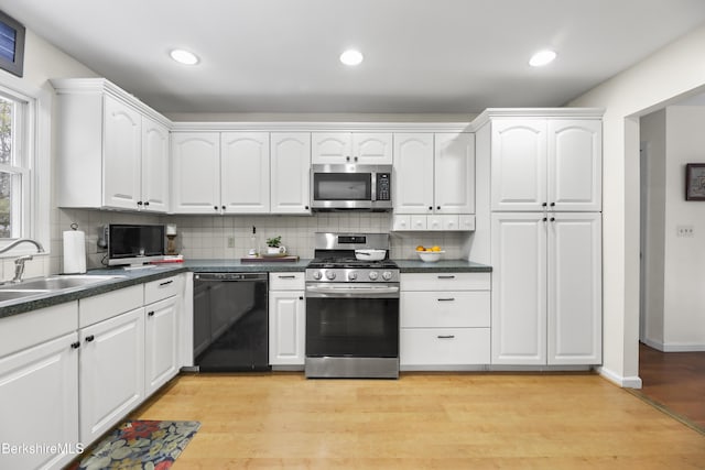 kitchen featuring appliances with stainless steel finishes, light hardwood / wood-style floors, white cabinets, and sink