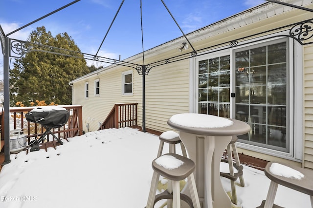 snow covered deck featuring area for grilling