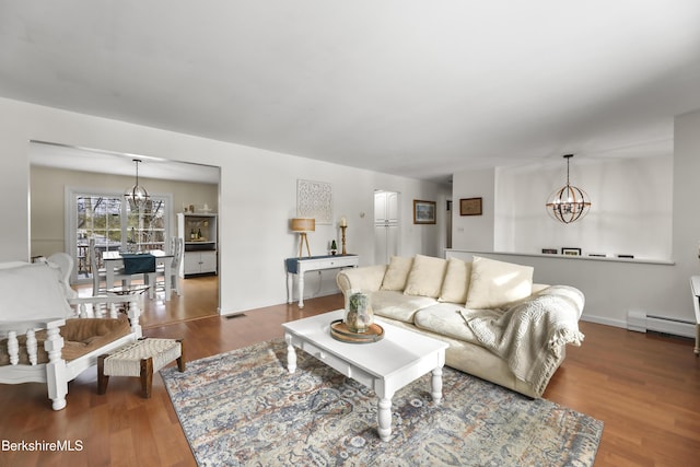 living room with dark hardwood / wood-style floors, a baseboard radiator, and a chandelier