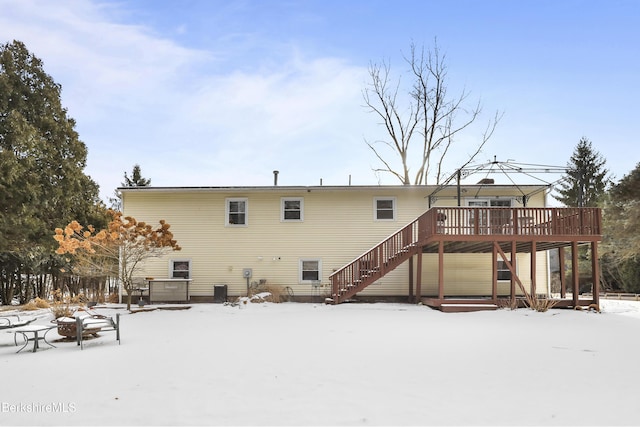 snow covered rear of property featuring a deck