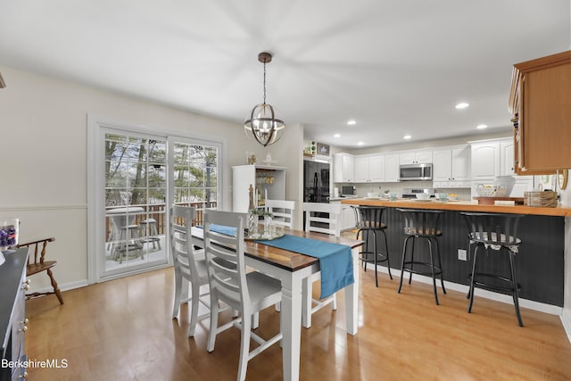 dining space featuring light wood-type flooring and a chandelier