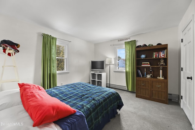 carpeted bedroom featuring a baseboard heating unit