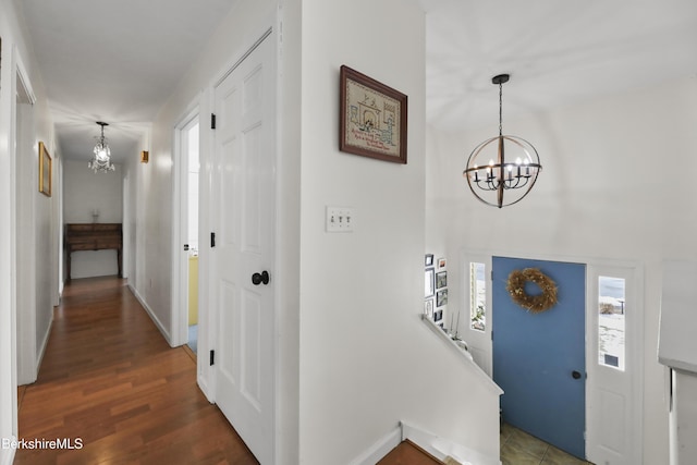 entrance foyer with a notable chandelier and dark wood-type flooring