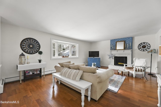 living room featuring a baseboard heating unit, a brick fireplace, and dark hardwood / wood-style flooring