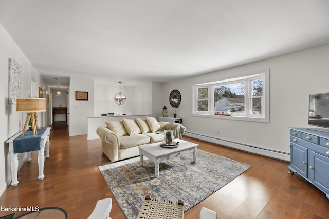 living room featuring a baseboard heating unit, a notable chandelier, and dark hardwood / wood-style floors