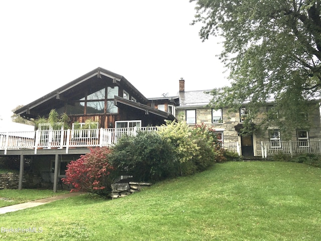 back of house featuring a deck and a yard