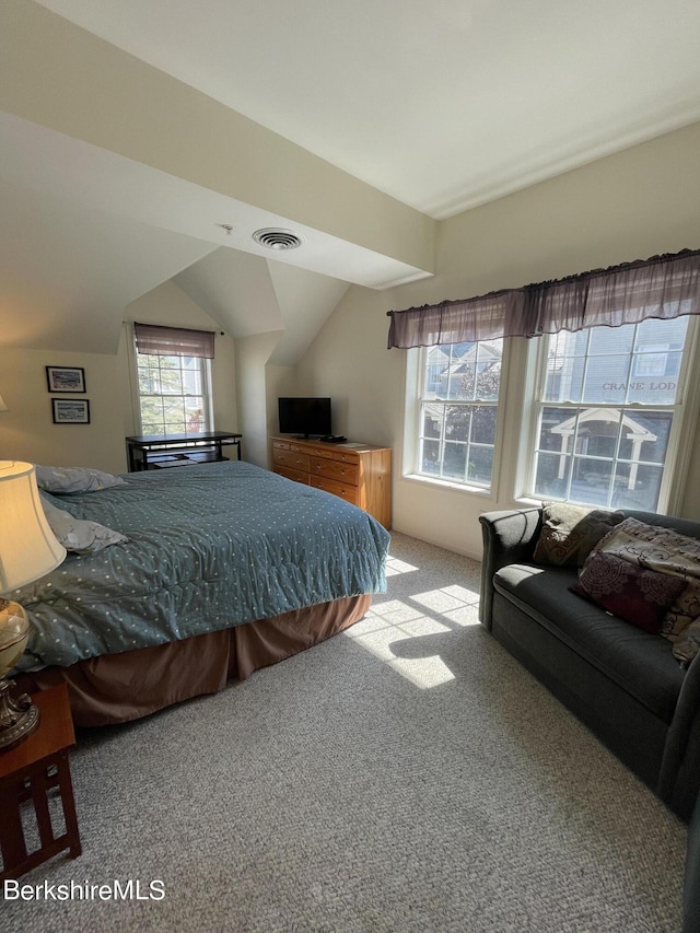 bedroom with vaulted ceiling and light colored carpet