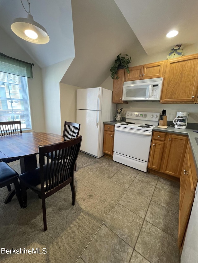 kitchen featuring hanging light fixtures, vaulted ceiling, light tile patterned floors, and white appliances