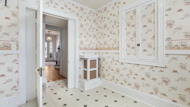 bathroom with baseboards and wallpapered walls