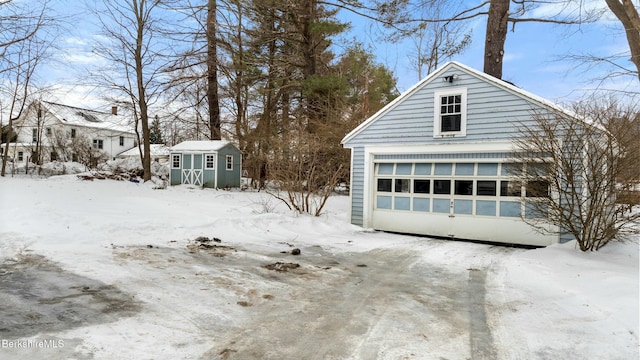 snow covered garage with a detached garage