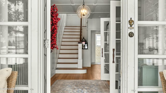 entryway with stairway, coffered ceiling, and wood finished floors