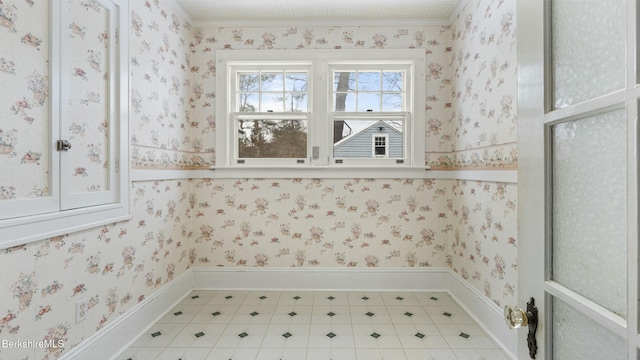 laundry area featuring light floors, wainscoting, and wallpapered walls