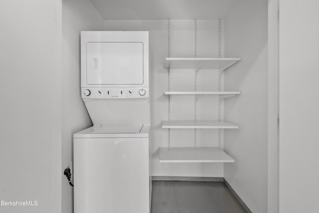 laundry room featuring stacked washer / drying machine