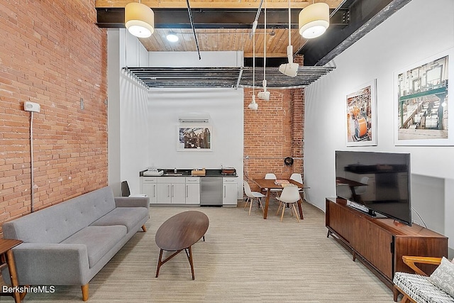 living room with a high ceiling, sink, and brick wall