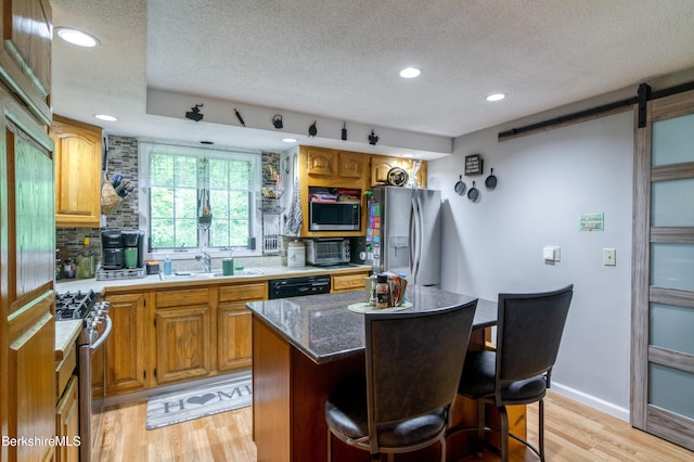 495 Williamstown Rd, Lanesborough, MA 01237 - kitchen with appliances with stainless steel finishes, a sink, light wood-type flooring, a textured ceiling, and a kitchen bar