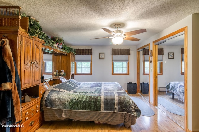 495 Williamstown Rd, Lanesborough, MA 01237 - bedroom with light wood-style flooring, multiple closets, a textured ceiling, and a ceiling fan