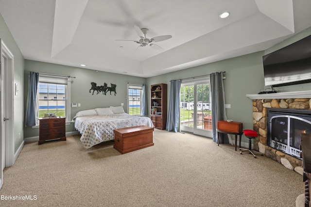 200 Easthampton Rd, Westhampton, MA 01027 - carpeted bedroom with a tray ceiling, a stone fireplace, ceiling fan, access to exterior, and recessed lighting