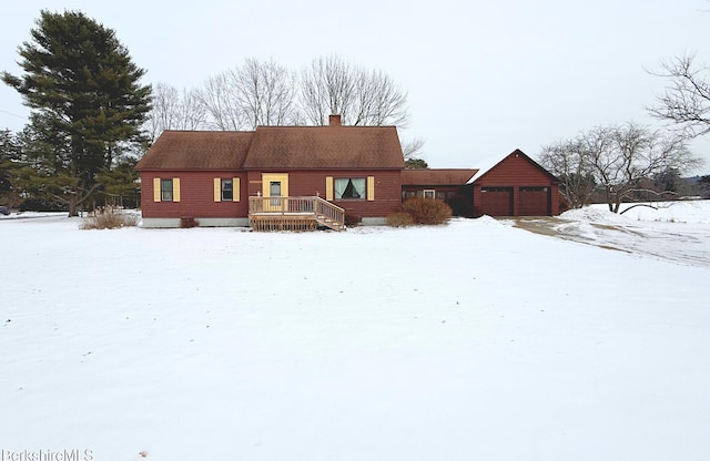 snow covered property featuring a garage and a deck