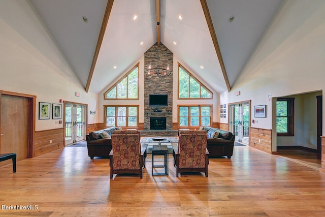 26 Autumn Ct, Otis, MA 01253 - living room featuring french doors, high vaulted ceiling, light wood finished floors, beam ceiling, and a stone fireplace