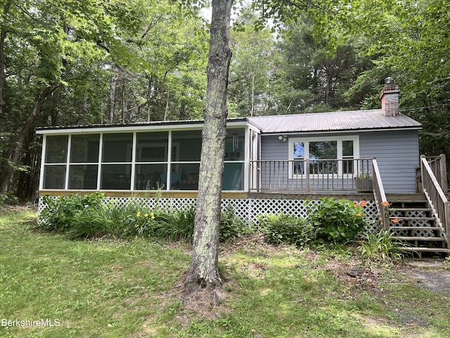40 N Lake Way, Becket, MA 01223 - view of front of house with a sunroom, a wooden deck, a metal roof, and stairs