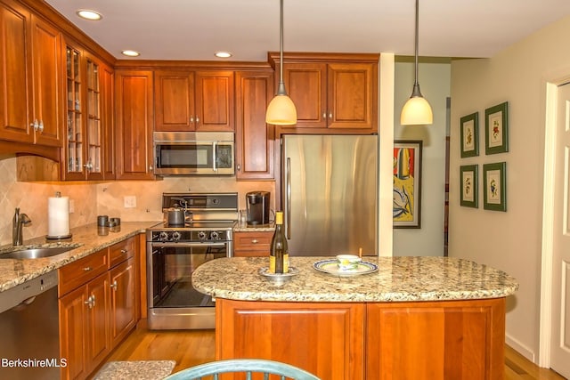 770 Summer St Unit 5D, Lee, MA 01238 - kitchen featuring appliances with stainless steel finishes, a sink, light stone counters, light wood-style flooring, and glass insert cabinets