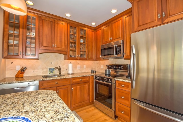 770 Summer St Unit 5D, Lee, MA 01238 - kitchen with appliances with stainless steel finishes, a sink, light stone countertops, recessed lighting, and glass insert cabinets