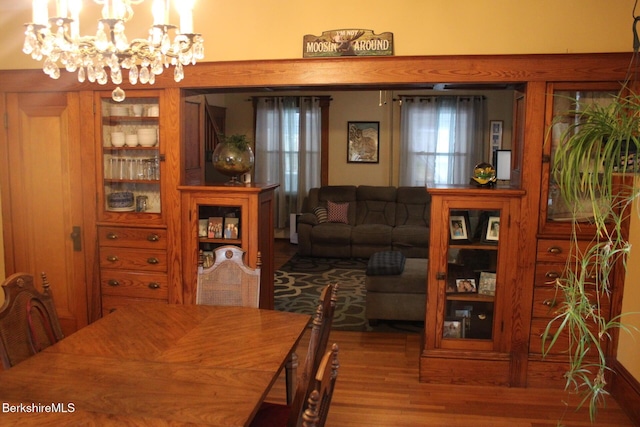 dining area with hardwood / wood-style floors and a notable chandelier