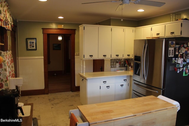 kitchen featuring ceiling fan, kitchen peninsula, stainless steel fridge with ice dispenser, ornamental molding, and white cabinets