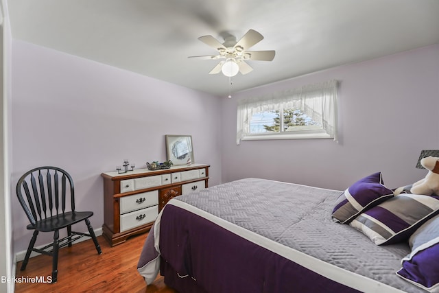 bedroom with ceiling fan, baseboards, and wood finished floors