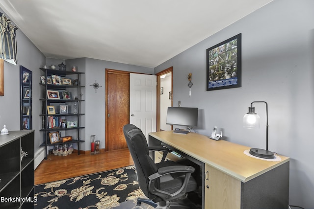 office with baseboard heating and wood finished floors