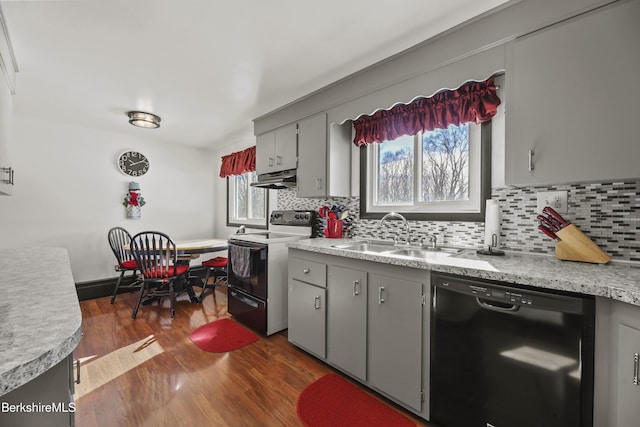 kitchen with gray cabinetry, under cabinet range hood, a sink, black dishwasher, and electric stove