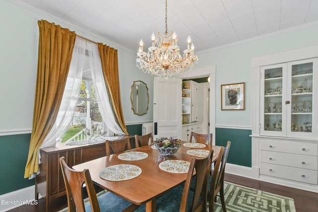 dining area with baseboards, ornamental molding, dark wood finished floors, and a notable chandelier