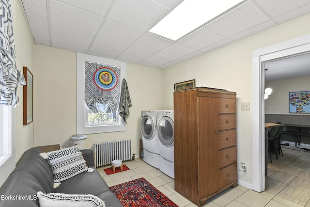 laundry area with laundry area, light tile patterned floors, radiator heating unit, and washing machine and dryer