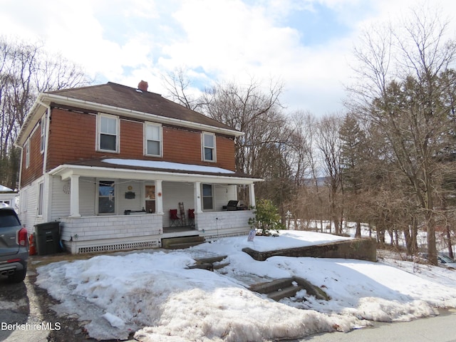 view of front of home with covered porch and a chimney