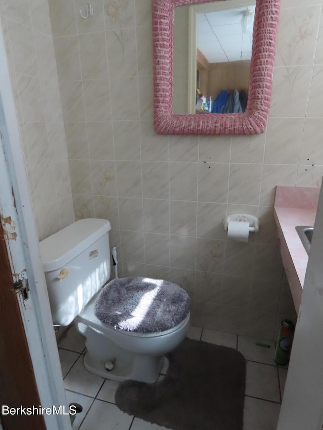 bathroom with tile walls, toilet, and tile patterned floors