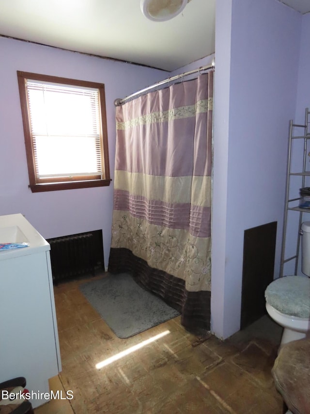 full bath featuring toilet, a shower with curtain, and radiator heating unit